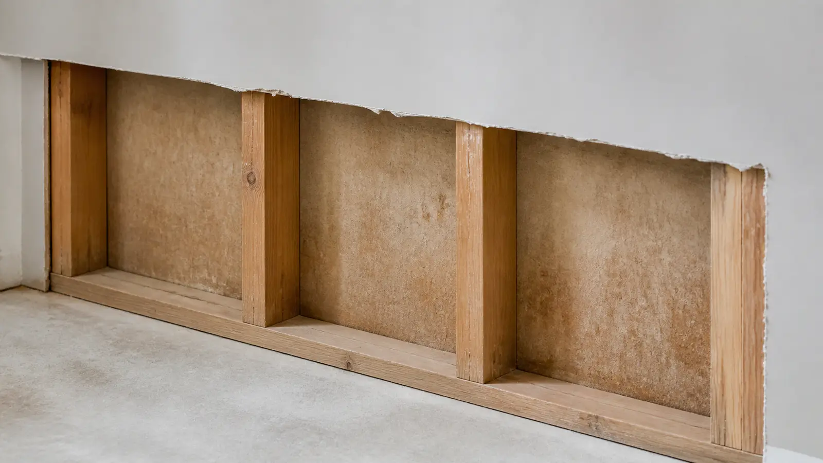Controlled drywall cut-back beside sound wall material