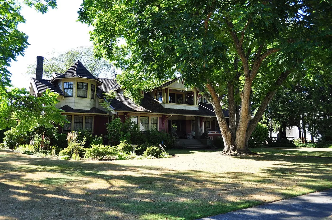 Craftsman bungalow with a deep porch under large shade trees in Centralia.