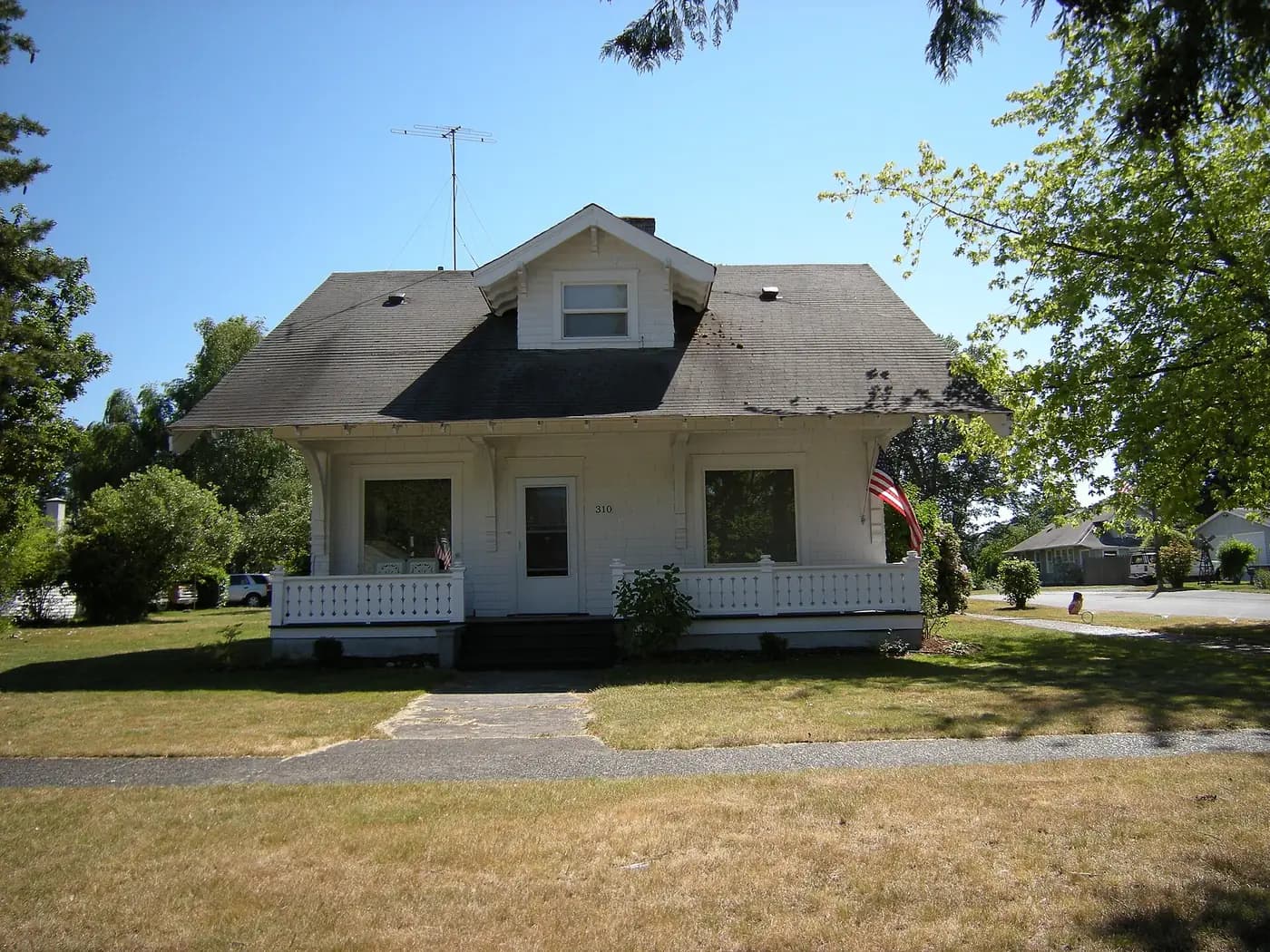 Single-story white house with a covered porch and a lawn in DuPont.