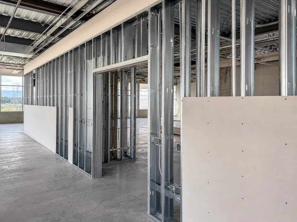 Light-gauge metal stud partition with coordinated openings and partial gypsum board installation