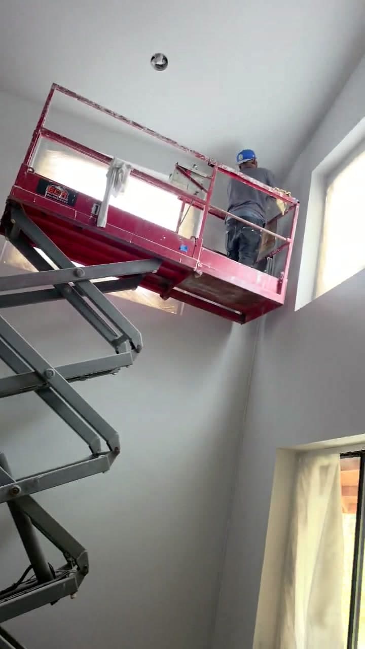 Video still showing the scissor lift raised for overhead work.