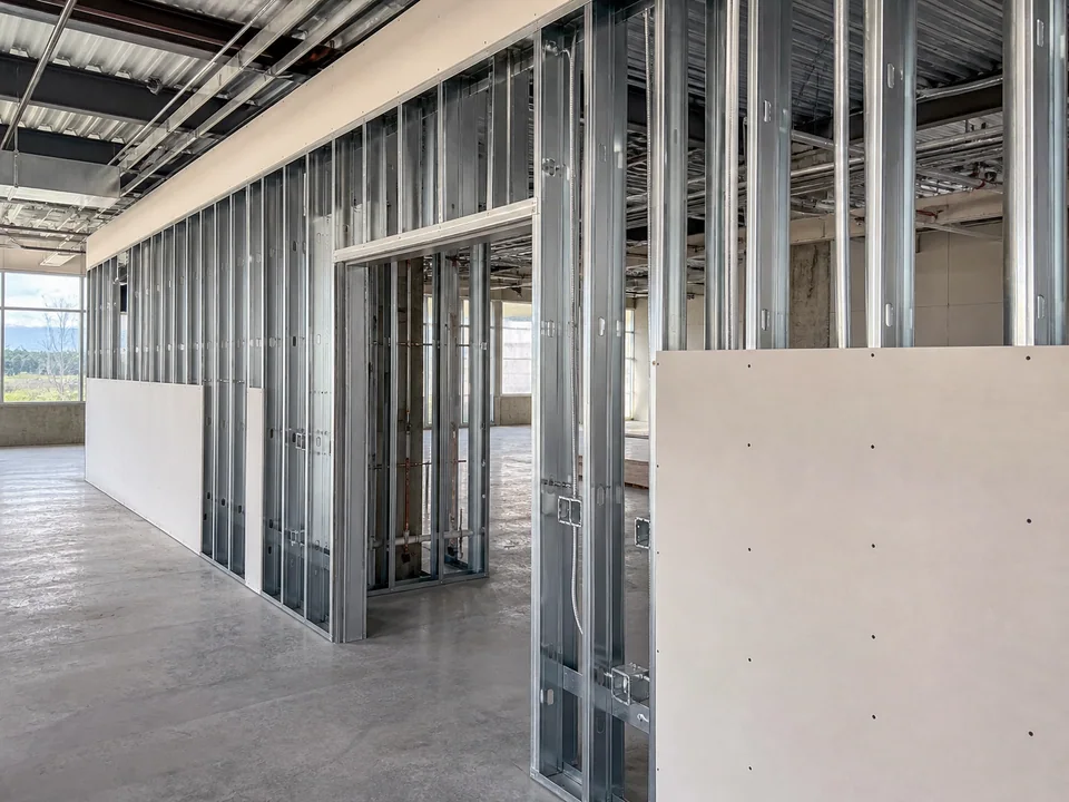 Light-gauge metal stud partition with coordinated openings and partial gypsum board installation