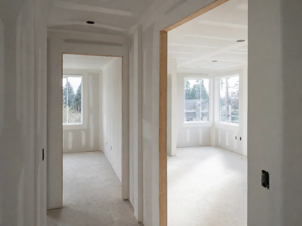 Repeated apartment interiors with coordinated taped drywall planes and shared-wall transitions
